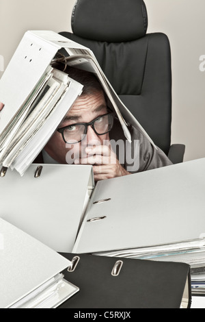 Ravvicinata di un imprenditore maturo in ufficio con i file sulla testata Foto Stock