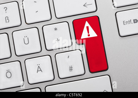 Close up di chiavi di computer con segnale di avvertimento sul tasto rosso Foto Stock