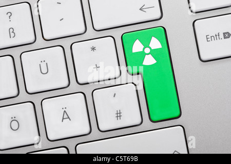 Close up di chiavi di computer con atom simbolo sul tasto verde Foto Stock
