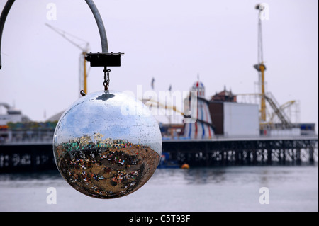 Grande argento riflettente la sfera pendente da un bar vicino la spiaggia di Brighton sul lungomare REGNO UNITO Foto Stock