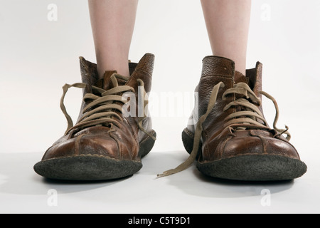 Bambino indossando scarpe di grandi dimensioni, bassa sezione, close-up Foto Stock