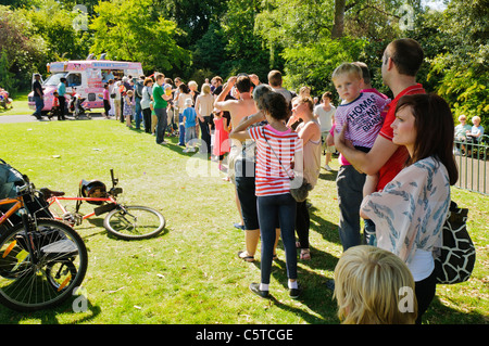 Molto lunga coda in un parco per un gelato Van Foto Stock