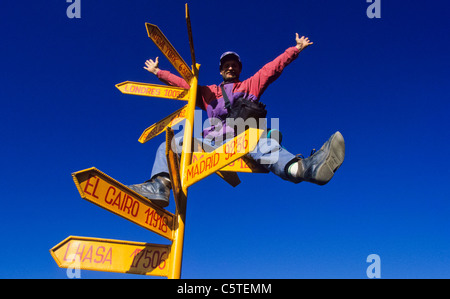 Viaggiatore e turista sulla parte superiore di un cartello giallo postare le principali città del mondo Foto Stock