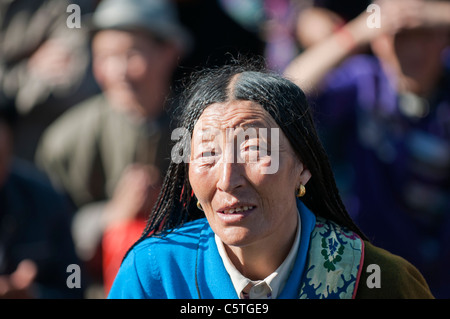 Pellegrino tibetano riverenti osserva Thangka, Buddha arazzo, al Monastero Kumbum, Huangzhong, Provincia di Qinghai, Cina Foto Stock