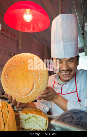 Pane baker mostrare il prodotto fresco in stallo alimentare, Mo Jaijie Mercato, Xining, Provincia di Qinghai, Cina Foto Stock