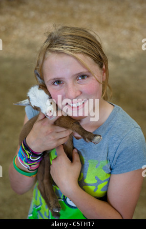 Un giovane a 4 H ragazza di cure per il suo bambino di capra al Lincoln County County Fair, svoltasi a Capitan, Nuovo Messico. Foto Stock