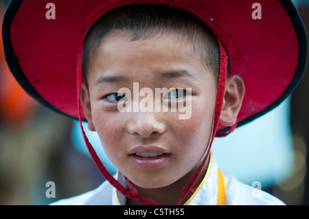 In un tempio buddista giovane abitante attende per eseguire a sciamano harvest festival, Tongren, Provincia di Qinghai, Cina Foto Stock