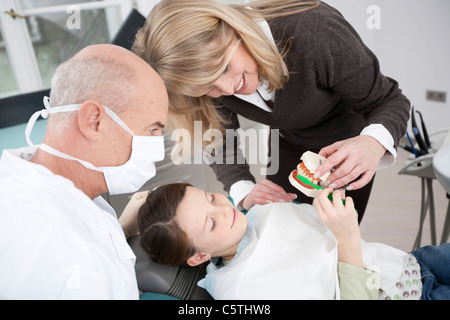 In Germania, in Baviera, Landsberg, madre mostra ragazza (8-9) come spazzola denti, dentista accanto Foto Stock