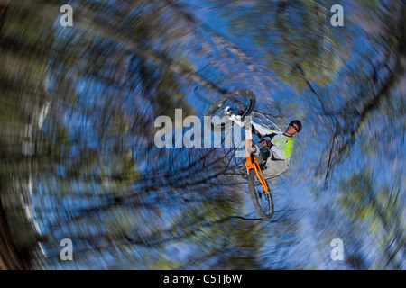 L'Italia, il lago di como, mountain biker prendendo un salto a basso angolo di visione Foto Stock