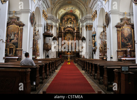 Uomo in preghiera nella chiesa pew vista posteriore, Mariahilfekirche Chiesa, Vienna, Austria, Europa Foto Stock