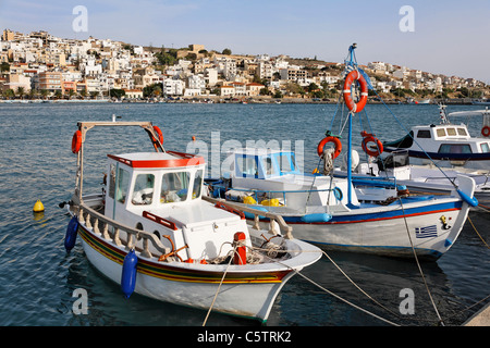 La Grecia, Creta, Sitia, barche da pesca ormeggiate in porto e città in background Foto Stock