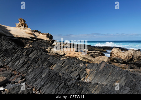 Spagna Isole Canarie Fuerteventura, Istmo de La Pared, Playa de Barlovento, rocce basaltiche che presso la spiaggia Foto Stock