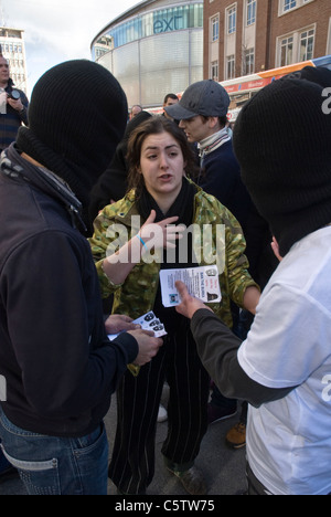 Un dibattito con passamontagna rivestito di difesa non inglesi i membri della lega con una donna durante l'EDL del piccolo raduno a Exeter City. Foto Stock