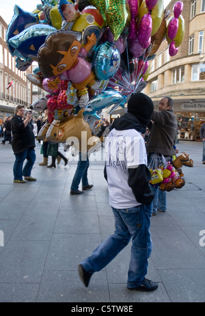 Non- Difesa inglese membro della Lega passeggiate passò un palloncino venditore durante l'EDL del piccolo raduno a Exeter City Center. Foto Stock