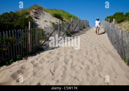 Donna percorrendo a piedi il sentiero sabbioso da Ryder Beach in Truro, Massachusetts Foto Stock