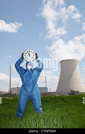 In Germania, in Baviera, Unterahrain, uomo in indumenti da lavoro protettiva azienda orologio a AKW Isar Foto Stock