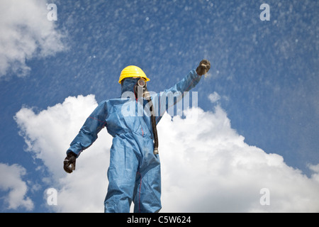 In Germania, in Baviera, uomo in indumenti da lavoro protettiva spargimento sabbia Foto Stock