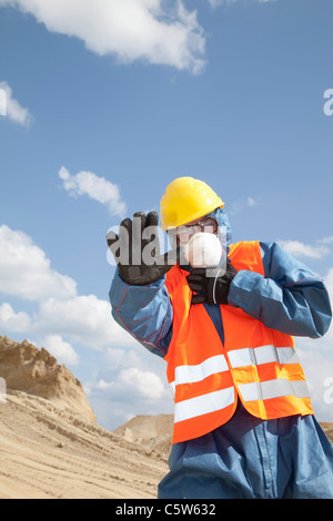 In Germania, in Baviera, uomo in indumenti da lavoro protettiva vicino a duna di sabbia Foto Stock