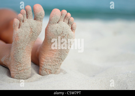 L'Italia, Sardegna, persona sdraiata sulla spiaggia sabbiosa di piedi Foto Stock