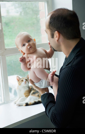 Padre dalla finestra azienda baby boy (6-11 mesi) Foto Stock