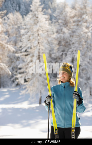 Austria, Tirolo, Seefeld, Wildmoosalm, Donna tenendo gli sci da fondo Foto Stock