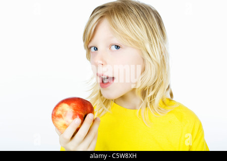 Ragazzo azienda Apple nella parte anteriore della sua bocca, ritratto Foto Stock