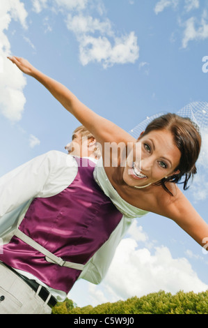 In Germania, in Baviera, Sposo sposa di sollevamento esterni, ridere, ritratto Foto Stock
