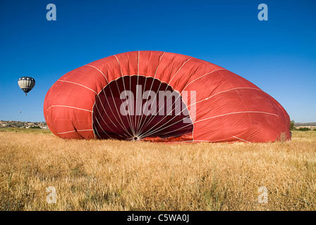 Turchia, Cappadocia, Goreme, vista di mongolfiere di atterraggio in un campo. Foto Stock