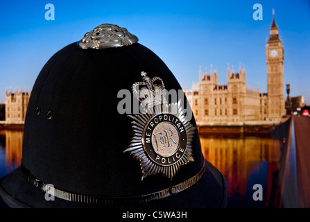 La Metropolitan Police casco e badge con le case del Parlamento e il fiume Tamigi Westminster London REGNO UNITO Foto Stock