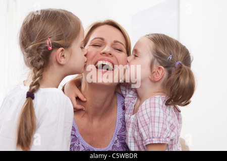 Germania - Monaco, ragazze (4-7) baciare sulla madre sua guancia Foto Stock
