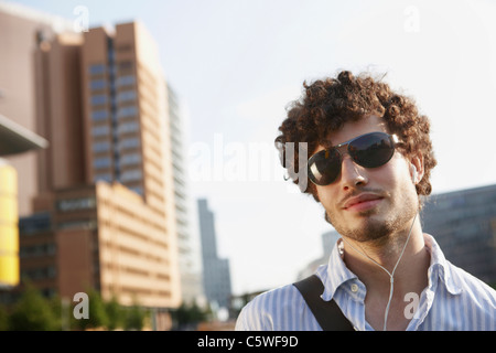 Germania Berlino, giovane uomo che indossa gli occhiali da sole, ritratto Foto Stock