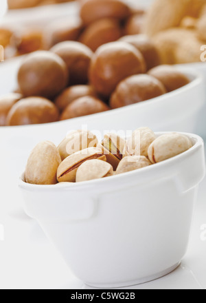 Pistacchi e altri dadi in ciotole Foto Stock