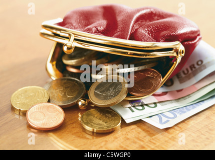 Close up di banconote e portamonete fuoriuscita delle monete in euro