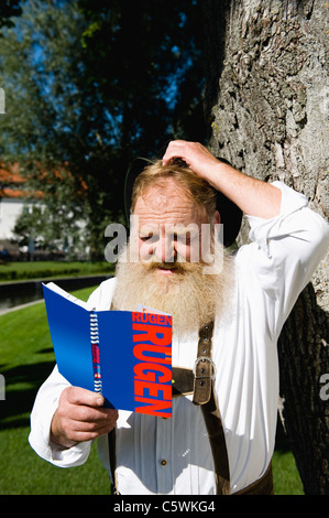 In Germania, in Baviera, Baviera, uomo bavarese la lettura di libri di viaggio, close-up Foto Stock