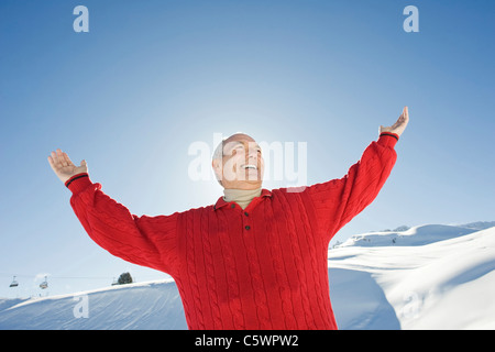 L'Italia, Alto Adige, Seiseralm, Senior uomo i bracci di sollevamento, sorridente, ritratto Foto Stock