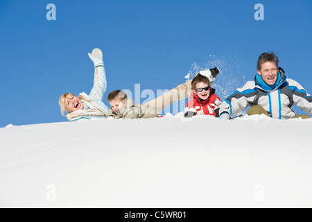 L'Italia, Alto Adige, Seiseralm, Famiglia giacente nella neve, ridere, ritratto Foto Stock