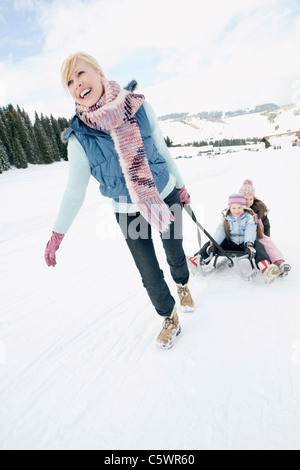 L'Italia, Alto Adige, Seiseralm, Donna tirando i bambini (6-7) (8-9) su sled Foto Stock