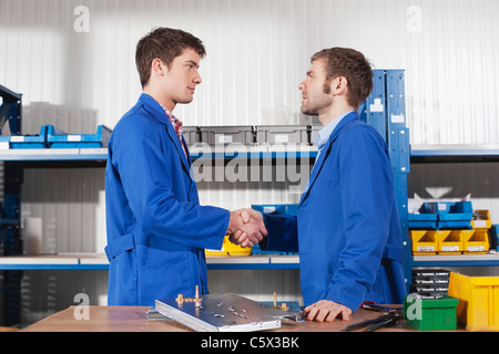 Germania, Neukirch, apprendista e istruttore stringono le mani, vista laterale, ritratto Foto Stock