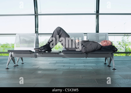 Germania, Leipzig-Halle, imprenditore nel airport lounge di partenza, dormendo sul banco di lavoro Foto Stock