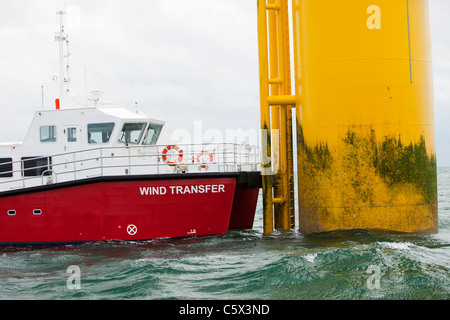 Un recipiente di alimentazione accanto ad una turbina eolica del Walney per centrali eoliche offshore project, off Barrow in Furness, Cumbria, Regno Unito. Foto Stock