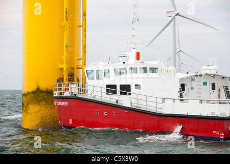 Un recipiente di alimentazione accanto ad una turbina eolica del Walney per centrali eoliche offshore project, off Barrow in Furness, Cumbria, Regno Unito. Foto Stock