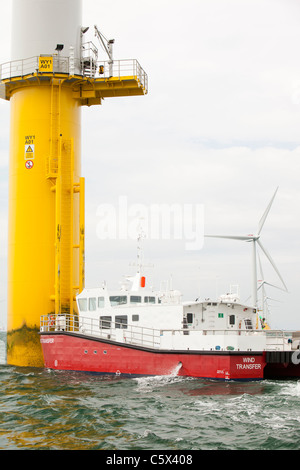 Un recipiente di alimentazione accanto ad una turbina eolica del Walney per centrali eoliche offshore project, off Barrow in Furness, Cumbria, Regno Unito. Foto Stock