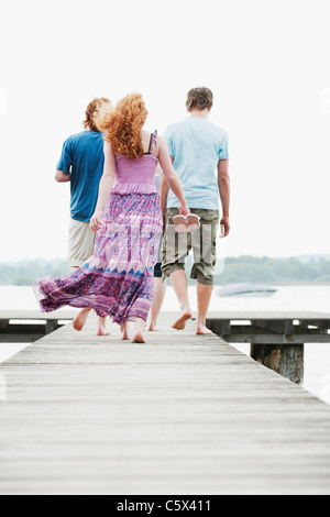 In Germania, in Baviera, Ammersee, quattro amici camminando sul molo, vista posteriore Foto Stock