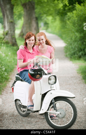 In Germania, in Baviera, giovane coppia con sulla mappa scooter Foto Stock