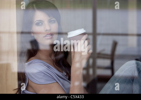Germania, Colonia, giovane donna seduta nella finestra di cafe Foto Stock