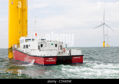 Un recipiente di alimentazione accanto ad una turbina eolica del Walney per centrali eoliche offshore project, off Barrow in Furness, Cumbria, Regno Unito. Foto Stock