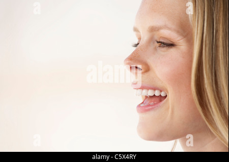 Giovane donna di ridere, vista laterale, ritratto Foto Stock