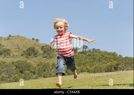 Spagna, Mallorca, ragazzo (3-4) in esecuzione su prato Foto Stock