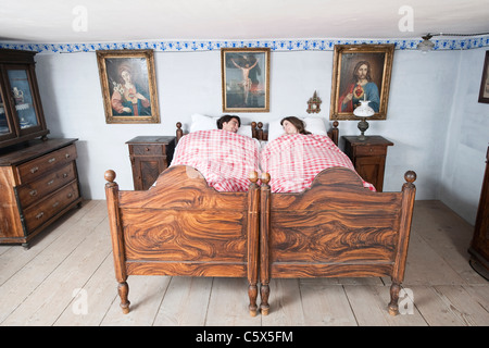 In Germania, in Baviera, coppia giovane giacente in camera da letto Foto Stock