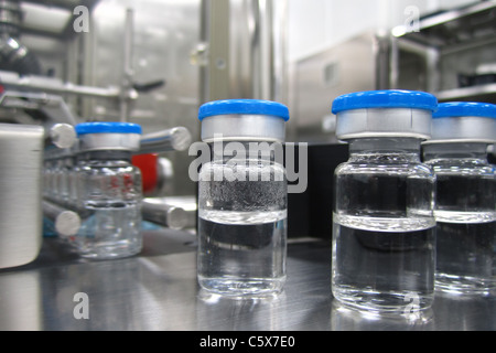 Bottiglie in macchina di lavorazione in uno stabilimento farmaceutico Foto Stock